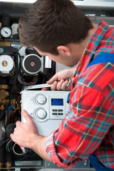 furnace technician working on heating system