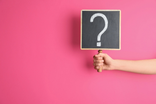 question mark sign held up by a hand depicting FAQs about wall vents open or closed