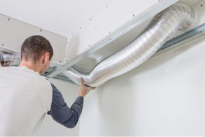 image of an HVAC contractor inspecting hvac ductwork