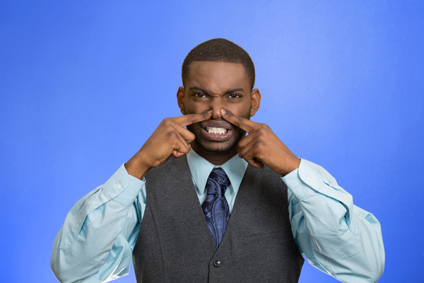 image of man covering nose from bad furnace odor