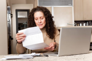 image of woman paying her energy bill and home heating costs