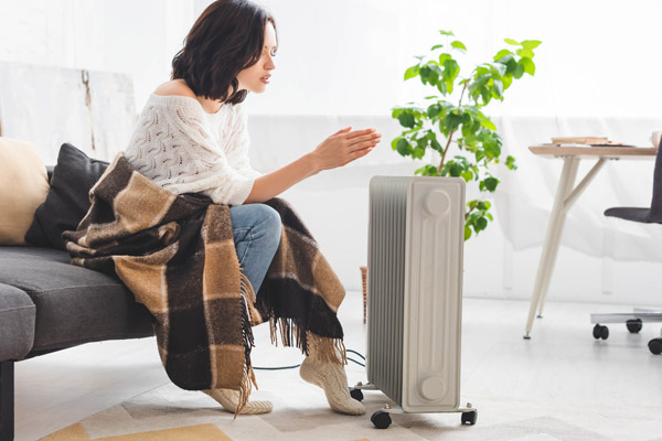 image of a woman using a space heater