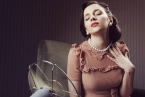 woman cooling herself with a fan