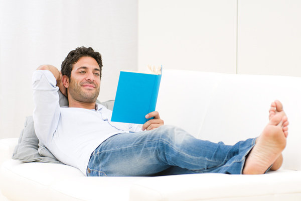man relaxing on couch enjoying home comfort