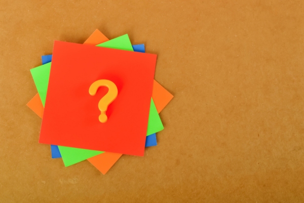 question mark on colored paper stack depicting FAQs about air conditioner sizing