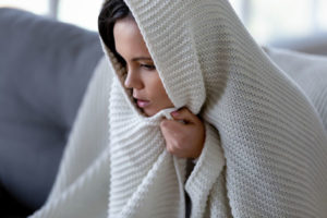 woman feeling cold due to poor furnace heating