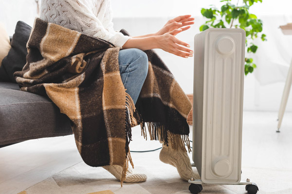 woman using space heater incorrectly