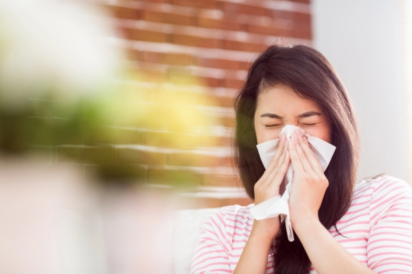 woman blowing her nose due to poor indoor air quality