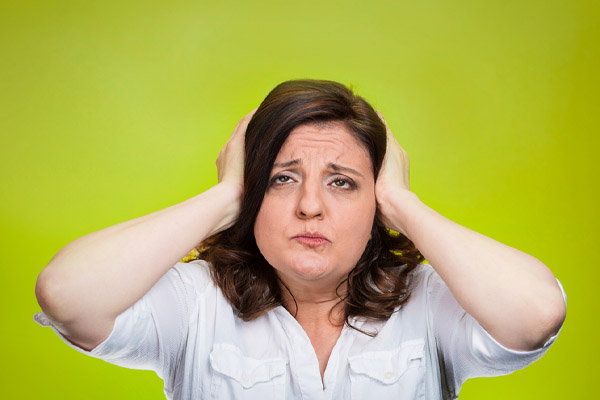 image of a homeowner covering ears due to AC unit making noise