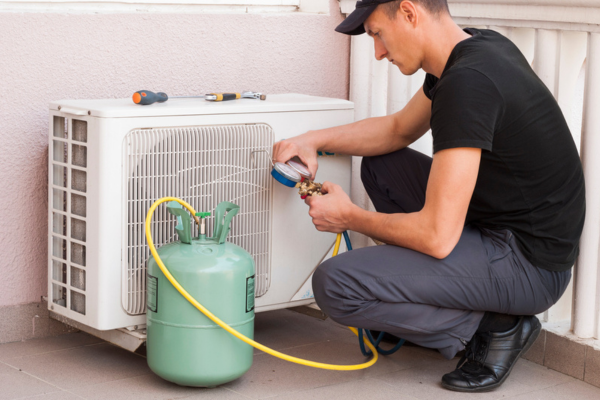 HVAC technician refilling an AC refrigerant