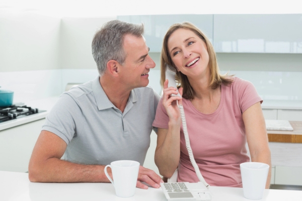 couple calling an HVAC professional from from home phone