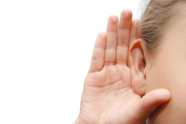 cropped view of a woman's head with hand cupping ear depicting listening to air conditioner