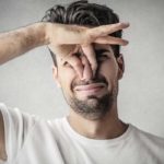 image of a homeowner plugging nose due to air conditioner smells