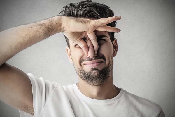 image of a homeowner plugging nose due to air conditioner smells