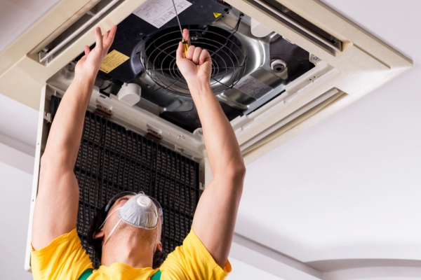 HVAC technician checking for mold growth on air conditioner