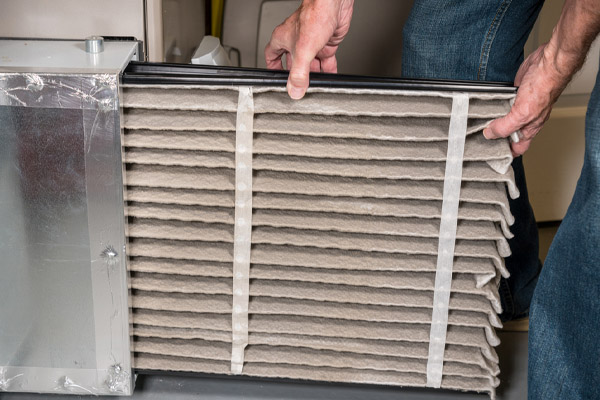 image of an hvac contractor replacing oil furnace filter