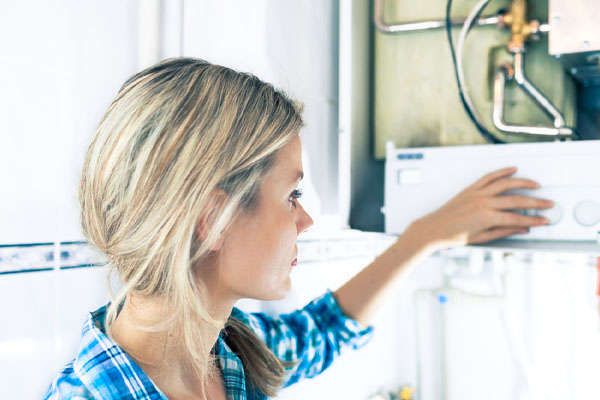 image of a homeowner adjusting a oil-fired water boiler