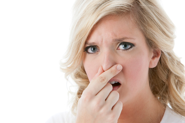woman plugging nose due to smelly air conditioner