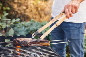 image of a homeowner grilling outside to prevent heat inside home