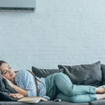 image of homeowner sleeping on couch using supplemental ductless heating