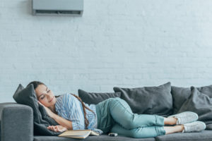 image of homeowner sleeping on couch using supplemental ductless heating