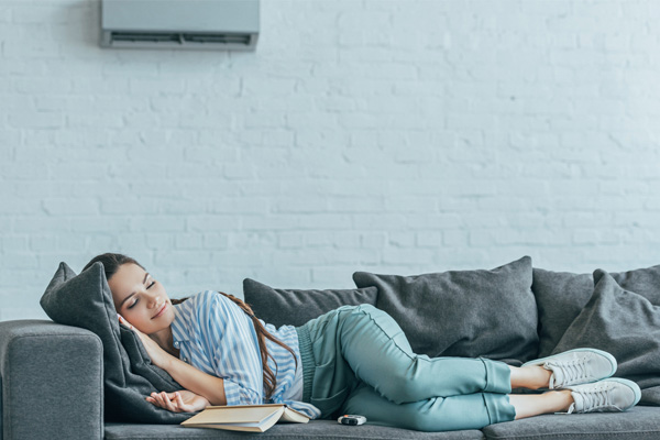 image of homeowner sleeping on couch using supplemental ductless heating