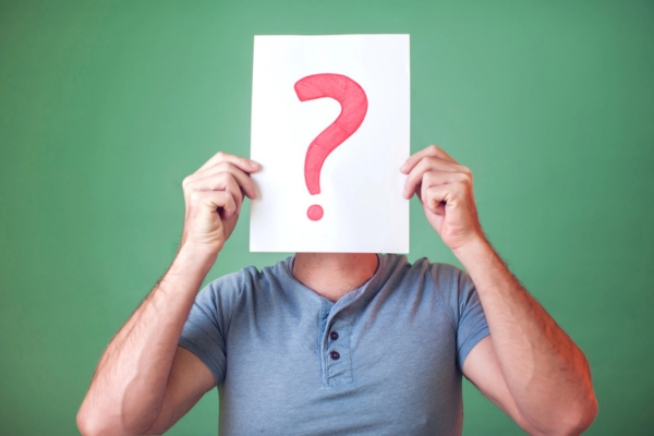 man holding question mark sign in front of his face depicting questions about Standby Generator Maintenance