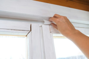image of a homeowner air sealing home due to window air leakage