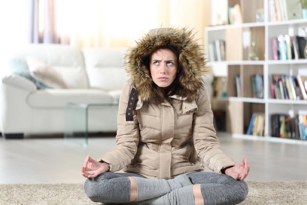 image of a homeowner feeling chilly due to heat pump not keeping up during winter