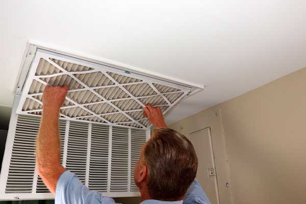 image of a man replacing his home air filter