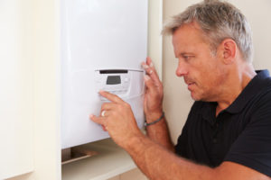 boiler technician servicing a domestic heating oil boiler and setting boiler temperature