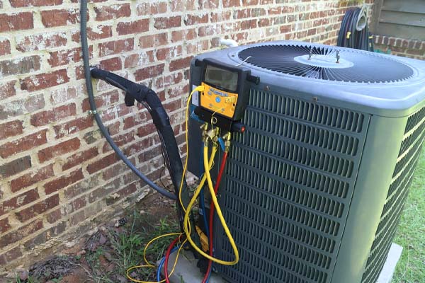 image of an hvac contractor checking air conditioner refrigerant levels