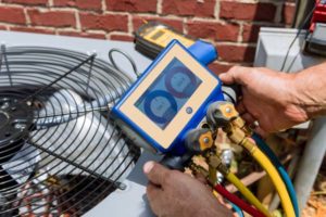 image of an hvac contractor examining ac unit refrigerant levels