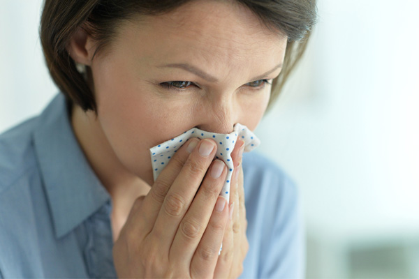 woman sneezing due to poor indoor air quality