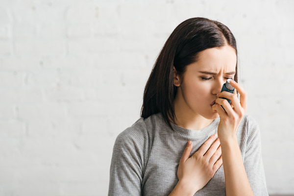 image of a homeowner experiencing asthma due to using an old ac unit at home