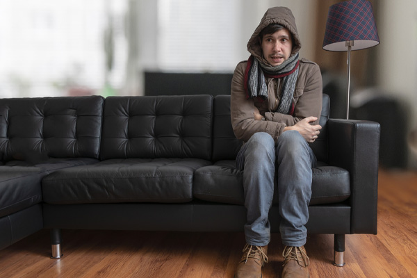 image of homeowner feeling chilly due to running out of heating oil in winter