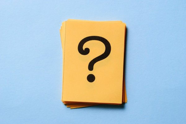 question mark on a stack of paper depicting HVAC Surge Protection FAQs