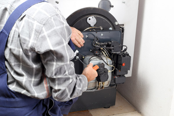 image of a boiler and an hvac contractor performing oil burner cleaning service