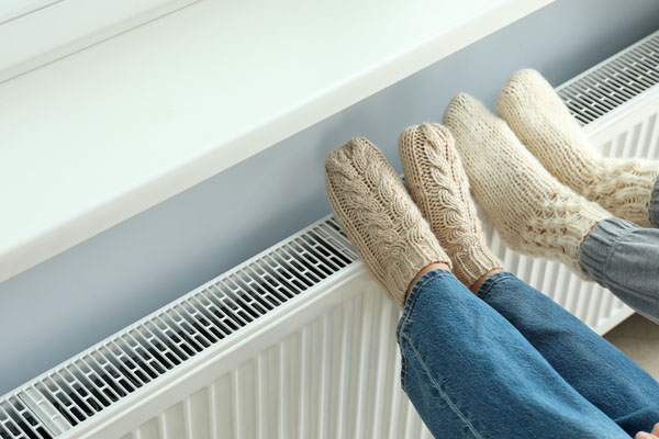 image of feet on radiator of an oil-fired heating system