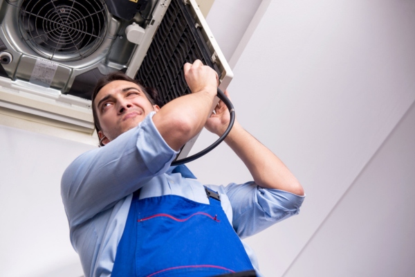 HVAC technician listening to AC sound