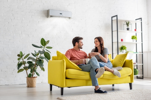 couple lounging on living room couch depicting good home ventilation