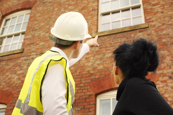 professional handyman and homeowner discussing home ventilation requirements