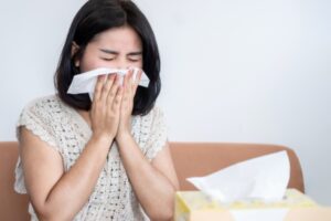 homeowner feeling sick with tissue on nose depicting poor indoor air quality