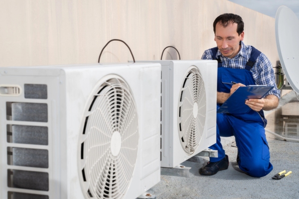 HVAC technician doing final inspection and post-installation checklist for air conditioner
