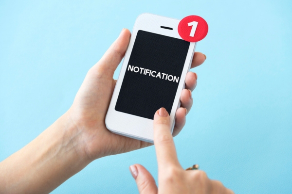 Human hands holding mobile phone with notification displayed on screen