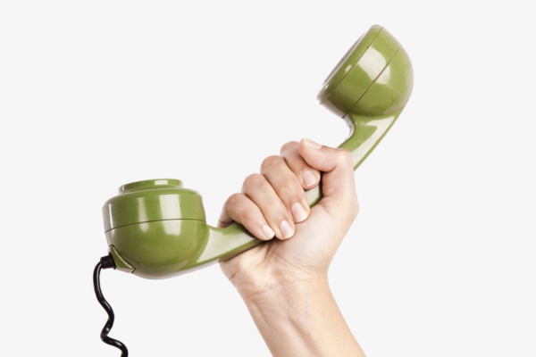 cropped view of a hand holding an old home phone depicting calling Lawes Company