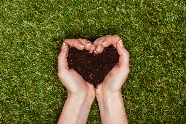 Cropped image of woman holding heart shaped soil in hands depicting eco-friendly and sustainable filters