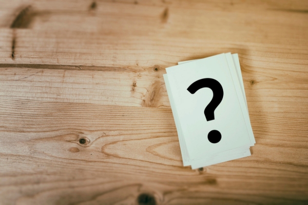 Question mark on wooden desk background depicting FAQs about Can Furnaces Work Without Filters
