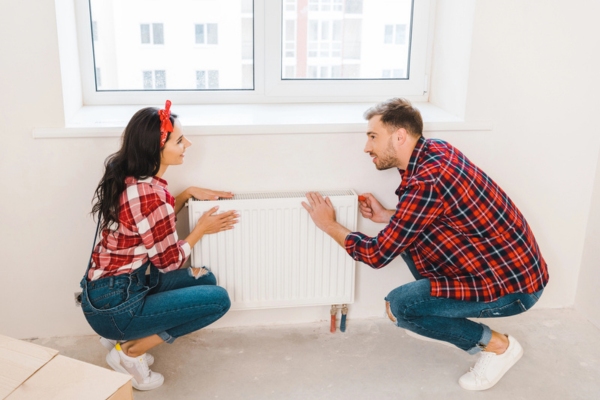 couple touching heating radiator preparing for maintenance
