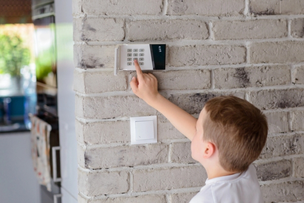 young boy pushing buttons in home alarm system